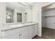 Bathroom with double vanity, granite counters, framed mirror, and access to closet at 823 E Agua Fria Ln, Avondale, AZ 85323