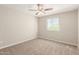 Bedroom features neutral paint, carpeted floors, ceiling fan, and a window with blinds at 823 E Agua Fria Ln, Avondale, AZ 85323