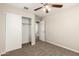 Bright bedroom featuring neutral walls, carpeted floors, and a closet with white sliding doors at 823 E Agua Fria Ln, Avondale, AZ 85323