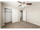Bedroom with neutral walls, carpeted floors, a ceiling fan and a closet with white doors at 823 E Agua Fria Ln, Avondale, AZ 85323