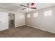 Spacious bedroom with ceiling fan, neutral carpet and views to the hallway at 823 E Agua Fria Ln, Avondale, AZ 85323