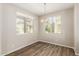 Bright dining area with wood flooring, chandelier, and views of the neighborhood from dual windows at 823 E Agua Fria Ln, Avondale, AZ 85323