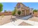Charming tan home featuring desert landscaping, covered entry, and sidewalk at 823 E Agua Fria Ln, Avondale, AZ 85323