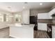 Bright kitchen features an island with granite counters, stainless sink and appliances and white cabinets at 823 E Agua Fria Ln, Avondale, AZ 85323