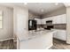 Spacious eat-in kitchen with white cabinetry, granite counters and stainless sink and black appliances at 823 E Agua Fria Ln, Avondale, AZ 85323