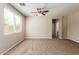 Spacious living room with carpet flooring, ceiling fan, and large window providing natural light at 823 E Agua Fria Ln, Avondale, AZ 85323