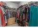 This fully stocked walk-in closet features ample hanging storage, open shelves and drawers at 872 E Saratoga St, Gilbert, AZ 85296