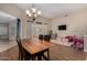 Comfortable dining area featuring a wooden table, chandelier, and a view of the playroom area at 927 S Ash St, Gilbert, AZ 85233