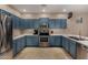 Spacious kitchen boasts stainless steel appliances, custom blue cabinetry, and ample counter space at 927 S Ash St, Gilbert, AZ 85233