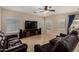 Inviting living room with tile floors, ceiling fan and large brown leather furniture at 927 S Ash St, Gilbert, AZ 85233