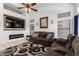 Stylish living room with decorative fireplace, vaulted ceilings, neutral paint, updated fan, and modern furnishings at 1022 S Butte Ln, Gilbert, AZ 85296