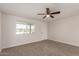 Inviting bedroom featuring plush carpeting, a modern ceiling fan, and natural light from a large window at 10693 N Arapaho Dr, Casa Grande, AZ 85122