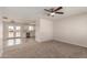 Comfortable living room with neutral carpet, ceiling fan, and an open view into the kitchen at 10693 N Arapaho Dr, Casa Grande, AZ 85122