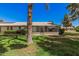 View of the back exterior showing a spacious backyard and partially shaded outdoor living and entertaining area at 10913 W Caron Dr, Sun City, AZ 85351
