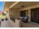 Inviting front porch featuring a comfortable chair, tiled flooring, and decorative brick accents at 10913 W Caron Dr, Sun City, AZ 85351