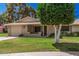 Charming single-story home with a well-manicured lawn, mature trees, and a quaint front porch at 10913 W Caron Dr, Sun City, AZ 85351