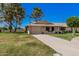 Inviting single-story home with a well-maintained lawn, mature trees, and a two-car garage at 10913 W Caron Dr, Sun City, AZ 85351