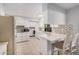 Bright and airy kitchen featuring white cabinets, quartz countertops, stainless steel appliances and a breakfast bar at 10913 W Caron Dr, Sun City, AZ 85351