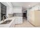 Well-lit kitchen with sleek white cabinets, stainless steel sink, breakfast bar, and plenty of counter space at 10913 W Caron Dr, Sun City, AZ 85351