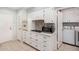 Functional kitchen with white cabinets, modern appliances, cooktop, and convenient access to the laundry area at 10913 W Caron Dr, Sun City, AZ 85351