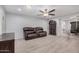 Comfortable living room with hardwood floors, ceiling fan, cozy seating, and a seamless flow to dining area at 10913 W Caron Dr, Sun City, AZ 85351