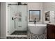Elegant bathroom with a glass-enclosed shower, soaking tub, and beautiful black and white tile design at 11829 W Patrick Ln, Sun City, AZ 85373