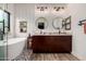 Bright bathroom featuring a modern soaking tub, dual vanities with granite countertops, and stylish tile accents at 11829 W Patrick Ln, Sun City, AZ 85373