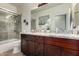 Well-lit bathroom featuring dual sinks, granite countertop, a shower and bathtub combo at 11829 W Patrick Ln, Sun City, AZ 85373