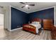 Another bedroom features wood furniture, great light, and stylish dark blue accent wall at 11829 W Patrick Ln, Sun City, AZ 85373