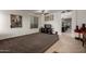 Open living room with brown carpet, tile flooring, and a view into the kitchen at 11829 W Patrick Ln, Sun City, AZ 85373