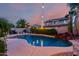 Inviting pool with rock feature, string lights, and desert landscaping creates a relaxing backyard oasis at 11829 W Patrick Ln, Sun City, AZ 85373