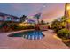 Desert oasis features a shimmering pool with lush landscaping and serene backyard ambiance at 11829 W Patrick Ln, Sun City, AZ 85373
