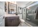 Bathroom featuring glass enclosed shower with herringbone tile, dark vanity, and a framed mirror at 12233 W Caraveo Pl, Peoria, AZ 85383