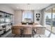 Dining area with modern light fixture, large table, seating for six, and decorative shelving at 12233 W Caraveo Pl, Peoria, AZ 85383