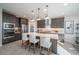 Open kitchen with island seating, stainless appliances, and stylish pendant lighting above island at 12233 W Caraveo Pl, Peoria, AZ 85383