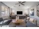 Cozy living room featuring ample seating, large windows, modern ceiling fan, and built in shelving at 12233 W Caraveo Pl, Peoria, AZ 85383