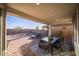 Covered patio featuring brick pavers, outdoor furniture, and a peaceful view of the backyard at 12233 W Caraveo Pl, Peoria, AZ 85383