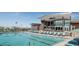 Community pool featuring plenty of lounge seating, nearby clubhouse, and desert landscape at 12233 W Caraveo Pl, Peoria, AZ 85383