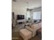 Bright living room featuring neutral decor, a ceiling fan, and comfortable white furnishings at 14991 W Shaw Butte Dr, Surprise, AZ 85379