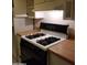 Functional kitchen features a gas range, wood countertops and white cabinets at 1622 E Campbell Ave # L, Phoenix, AZ 85016
