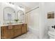 Updated bathroom featuring double sinks, decorative mirrors, and a tub with a shower at 16428 N 59Th St, Scottsdale, AZ 85254