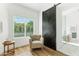 Bright bathroom showcases a barn door, light tan chair, hardwood floors, and view to the outside at 16428 N 59Th St, Scottsdale, AZ 85254