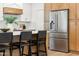 Stainless steel refrigerator next to the kitchen island with bar seating at 16428 N 59Th St, Scottsdale, AZ 85254