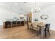 Open kitchen and dining room featuring white cabinets, wood accents, stainless steel appliances, and modern lighting at 16428 N 59Th St, Scottsdale, AZ 85254