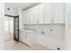 Clean, bright laundry room with modern white cabinets and stylish tiled floors at 16428 N 59Th St, Scottsdale, AZ 85254