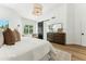 Bright main bedroom offers hardwood floors, a modern light fixture, and a view of the en suite bathroom at 16428 N 59Th St, Scottsdale, AZ 85254