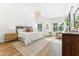 Spacious main bedroom with white walls, hardwood floors, a patterned rug, and a stylish modern chandelier at 16428 N 59Th St, Scottsdale, AZ 85254