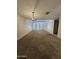 Spacious living room featuring neutral carpet, modern lighting, and access to the patio at 189 Laguna E Dr, Litchfield Park, AZ 85340