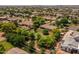 Wide aerial view showcasing lush landscaping, mature trees, and surrounding homes in a verdant neighborhood at 21228 E Excelsior Ave, Queen Creek, AZ 85142