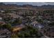 Dusk aerial view of a neighborhood with homes, lush landscaping, and mountain views in the background at 21228 E Excelsior Ave, Queen Creek, AZ 85142